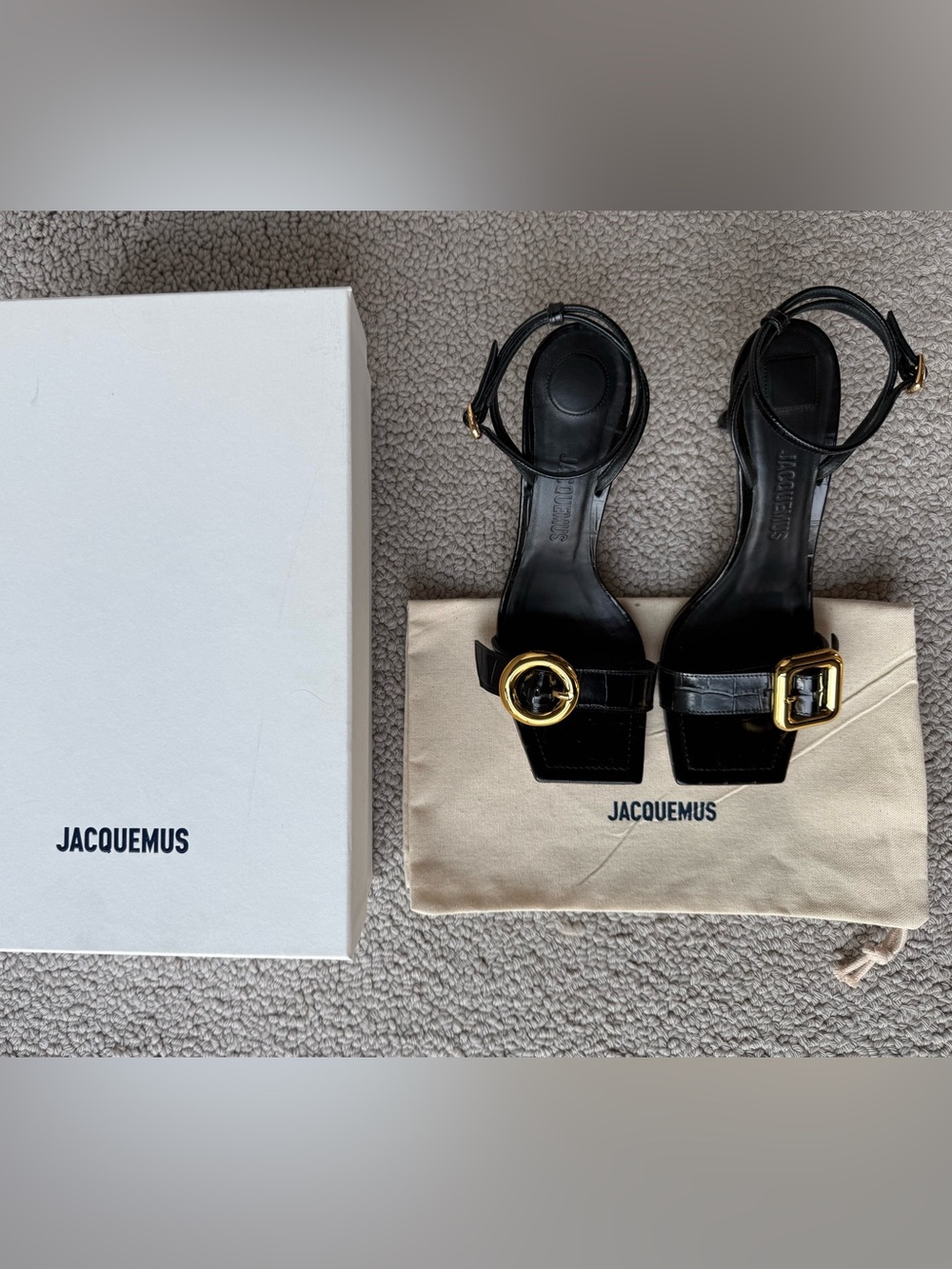 Jacquemus Black Leather Square-Toe Sandals with Gold Circle and Square Buckle.